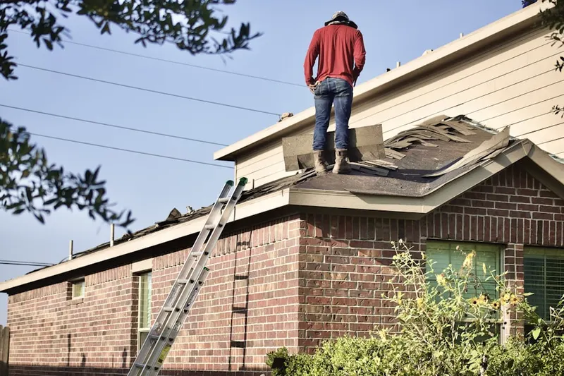 Professional roofer working on a residential roof in Tontitown